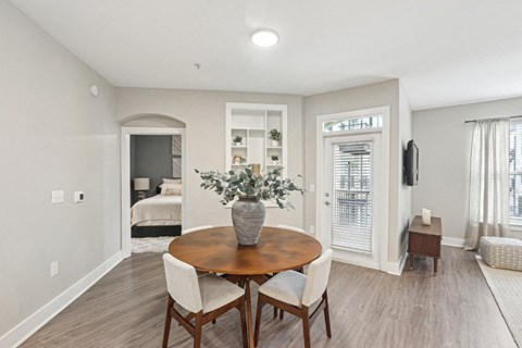 A dining room with a wooden table and chairs.