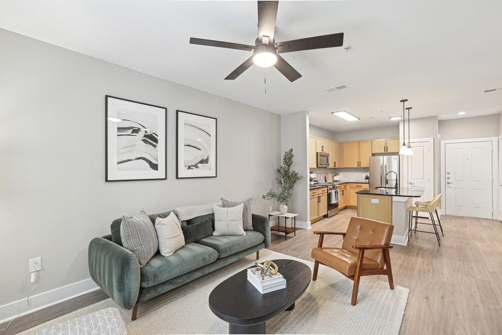 A living room with a green couch and a ceiling fan.