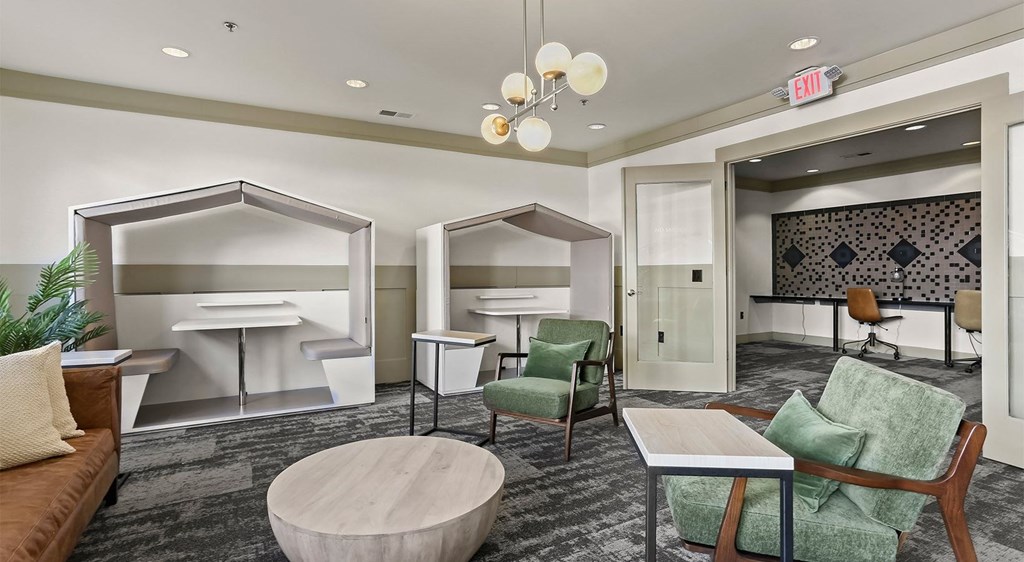 a lounge area with chairs and tables and a kitchen