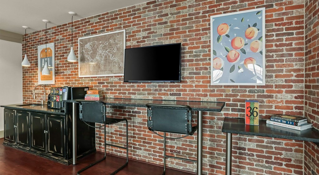 a brick wall in a living room with two desks and a television