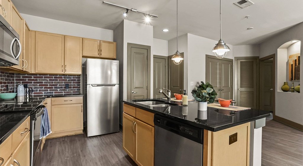 a kitchen with wooden cabinets and a stainless steel refrigerator