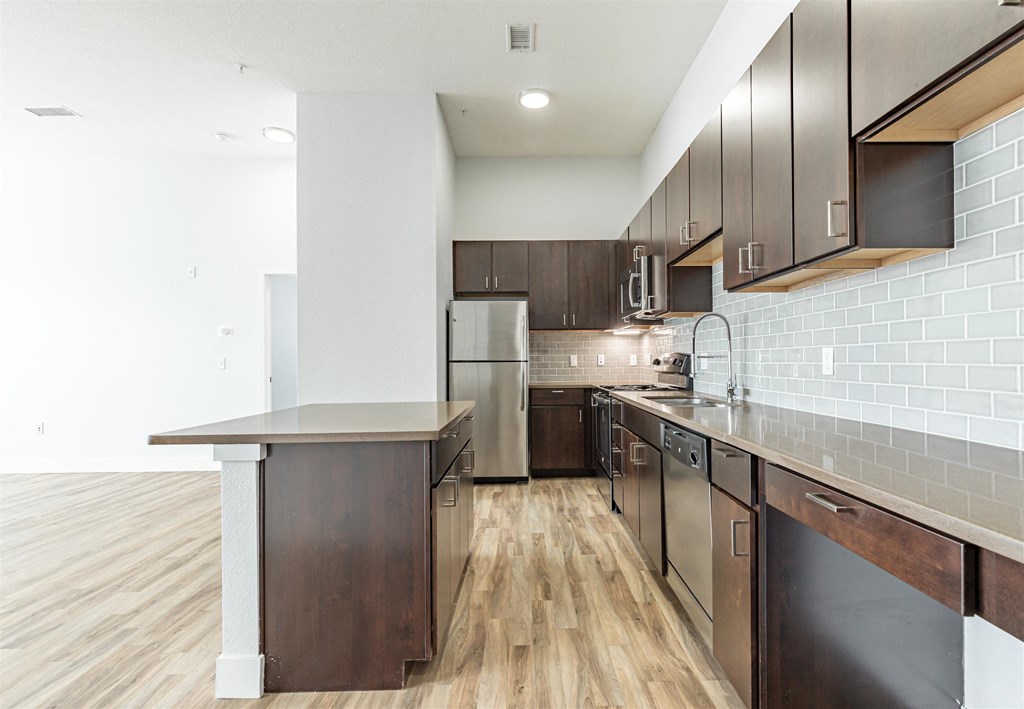 a kitchen with dark wood cabinets and stainless steel appliances
