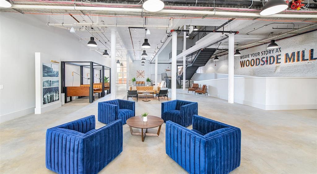 an open office space with blue chairs and a table