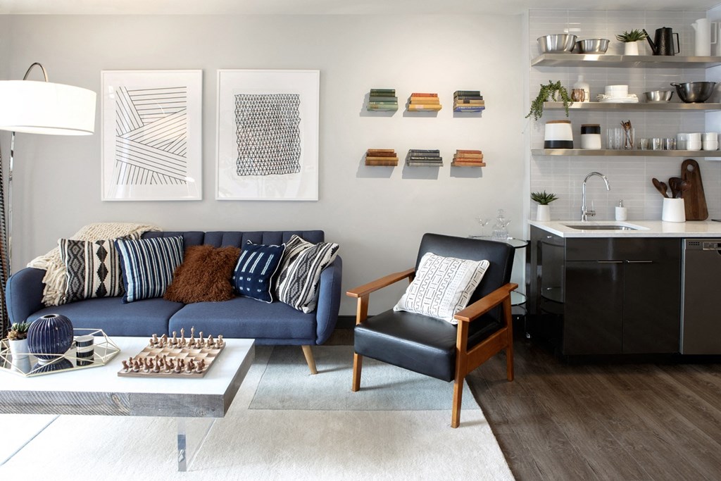a living room with a blue couch and a kitchen