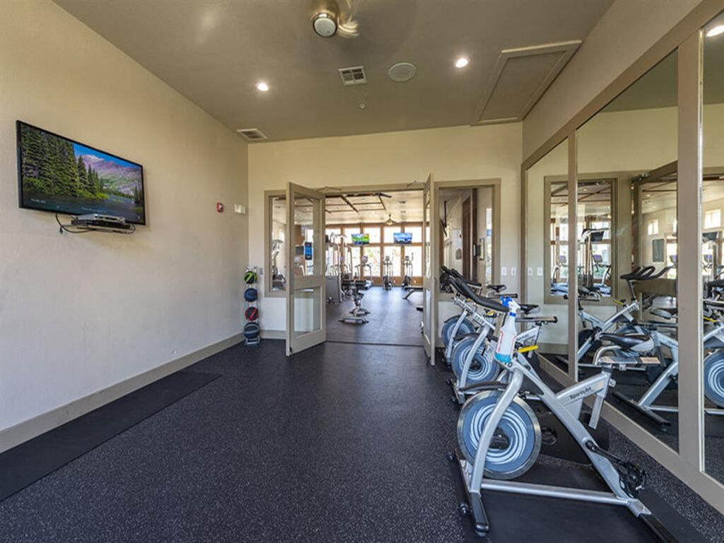 a room with a lot of bikes in it and a tv on the wall