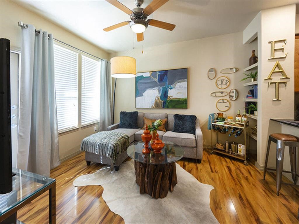 a living room with a couch a table and a ceiling fan