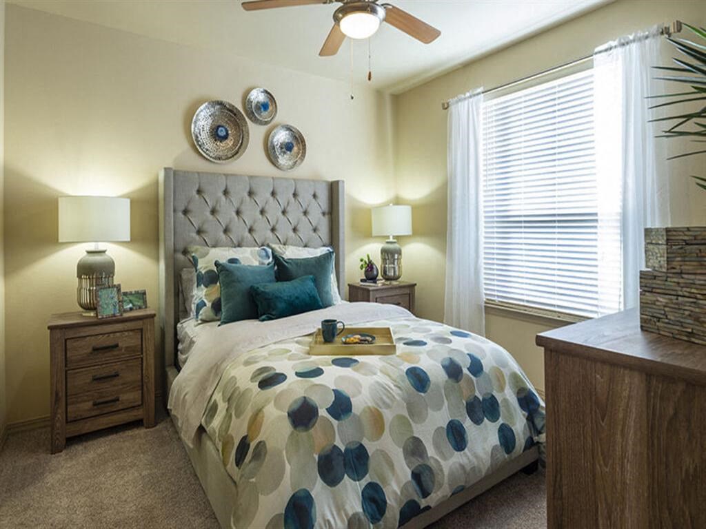 a bedroom with a bed and a ceiling fan