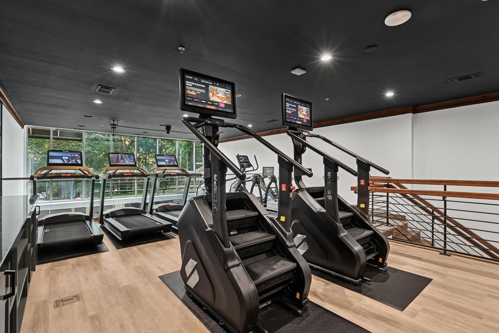A gym with treadmills, elliptical machines, and a stair climber.
