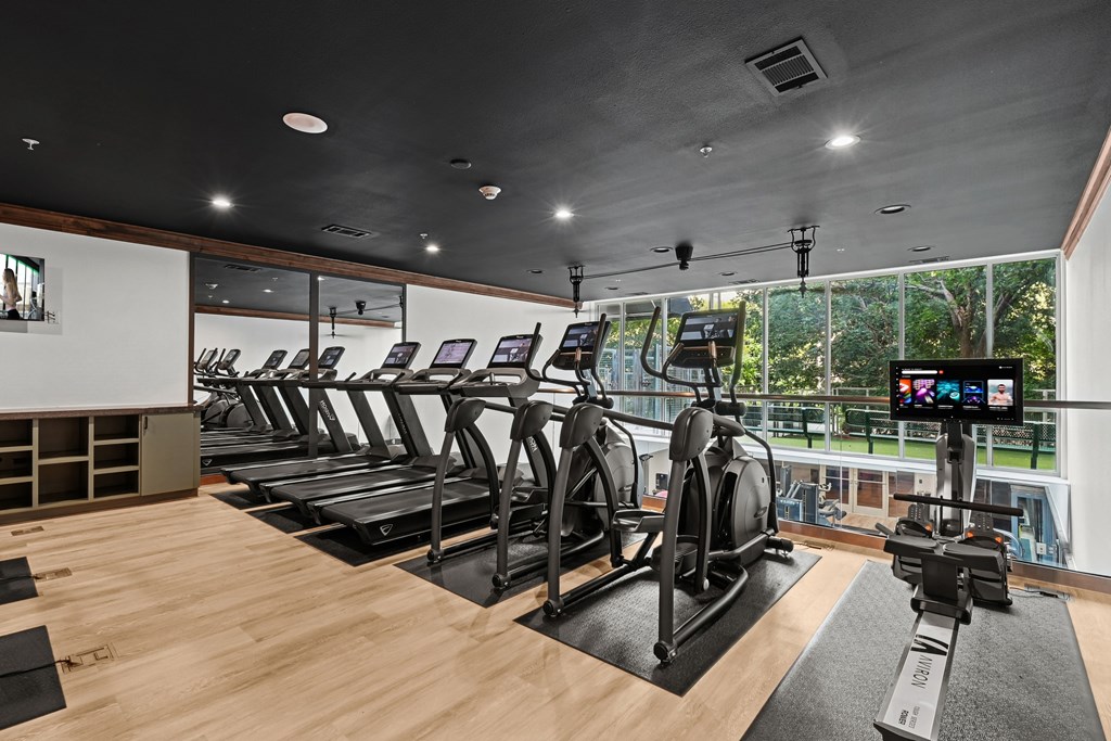 A gym with treadmills and elliptical machines.