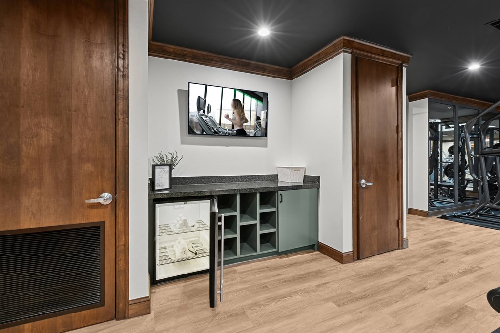 A modern kitchen with a wooden door and a fridge.