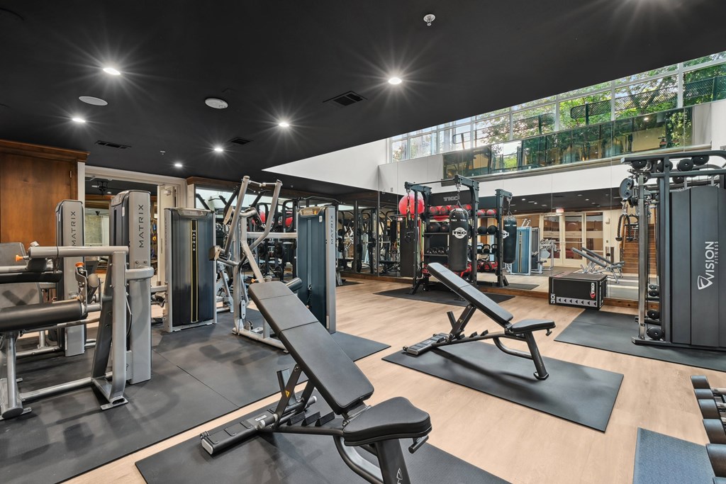 A gym with a variety of equipment including weights and benches.