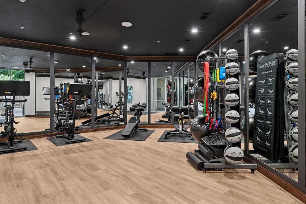 A gym with a variety of equipment including weights and treadmills.