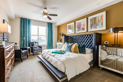 A bedroom with a large bed and a ceiling fan.
