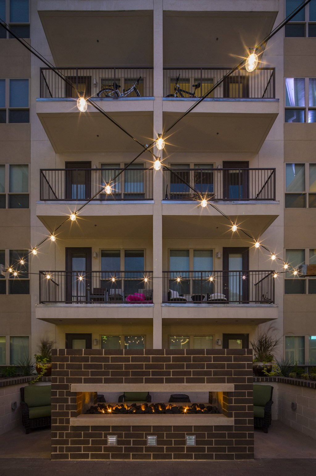 A fireplace is in the middle of a courtyard surrounded by apartment buildings.