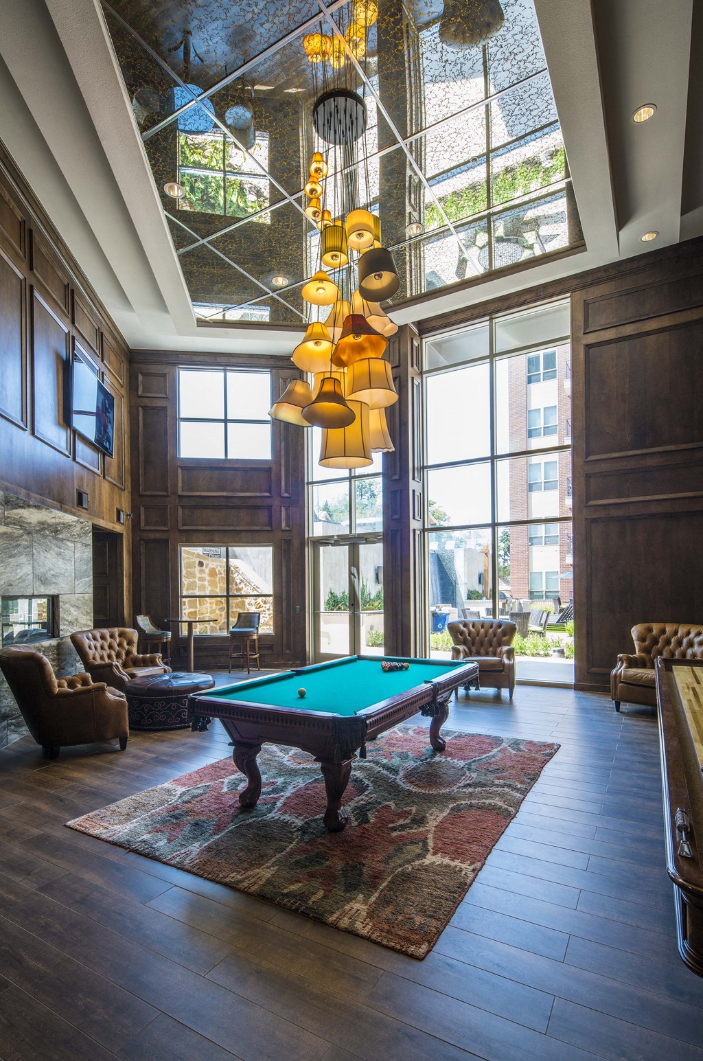 A pool table is in the middle of a room with a large window.