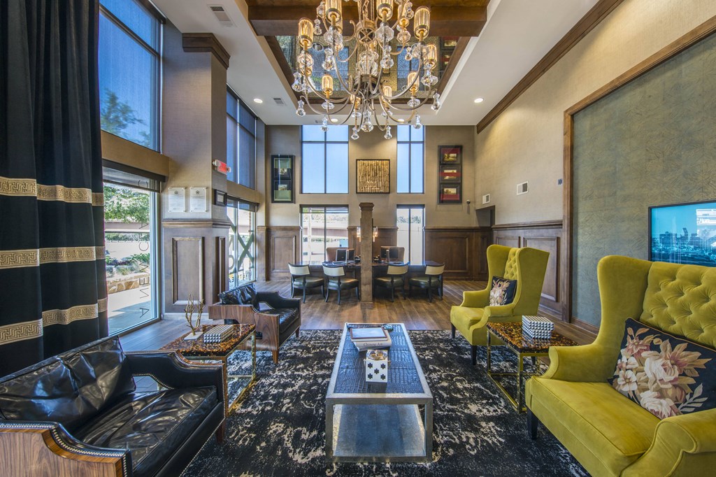 A living room with a yellow chair and a black and gold sofa.