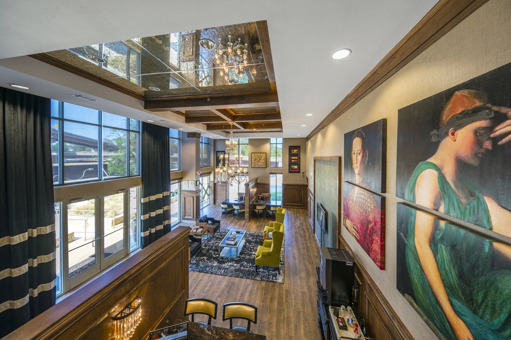 A woman in a green dress is the focus of a painting in a room with a wooden floor and a chandelier.