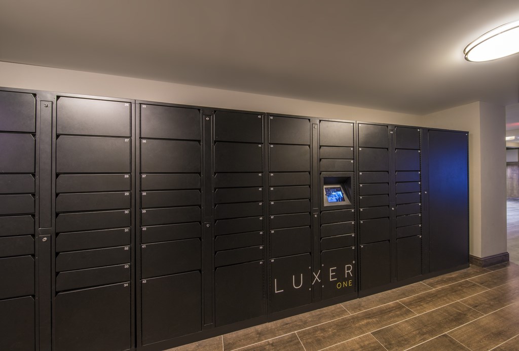 A row of black lockers with a sign that says "LUXER ONE".