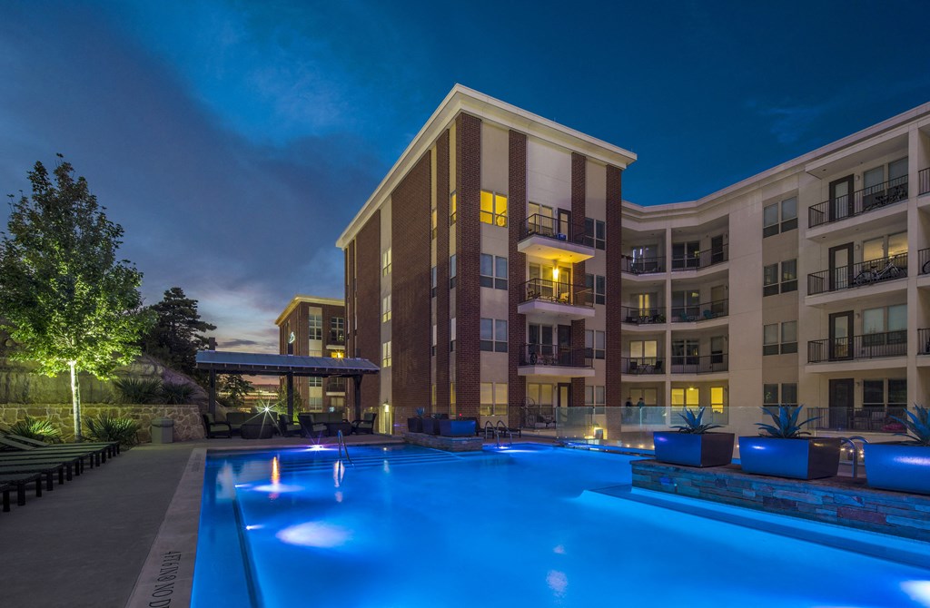 A large building with a pool in front of it.