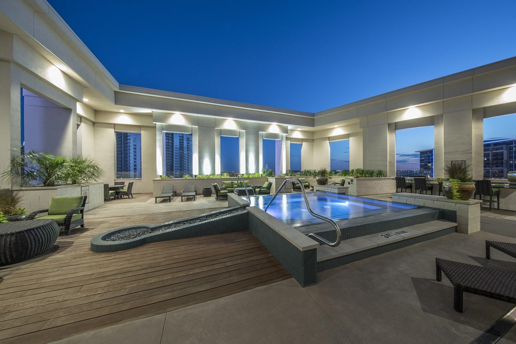 A modern outdoor pool area with a hot tub and seating area.