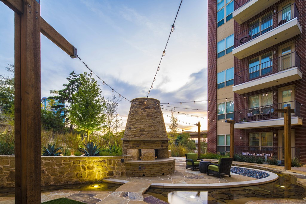 A backyard with a swing set and a fire pit.