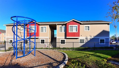 an apartment building with a playground in front of it
