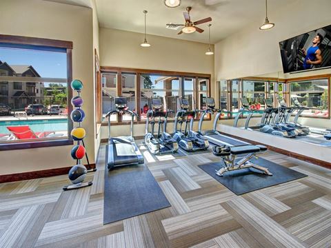 a gym with weights and a pool and a tv