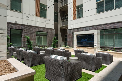 an outdoor seating area with wicker furniture in front of an office building