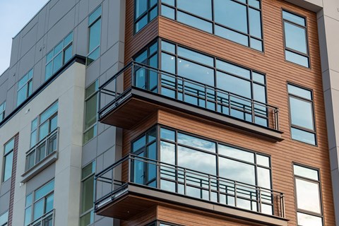 an exterior view of a building with glass windows and balconies