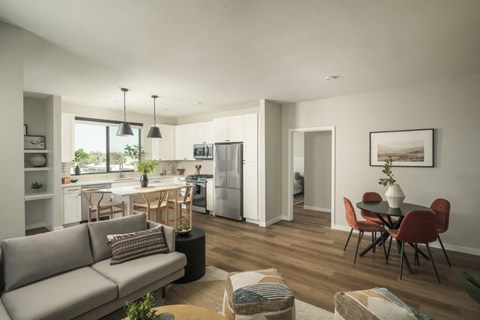 A modern living room with a grey sofa and a dining table with chairs.