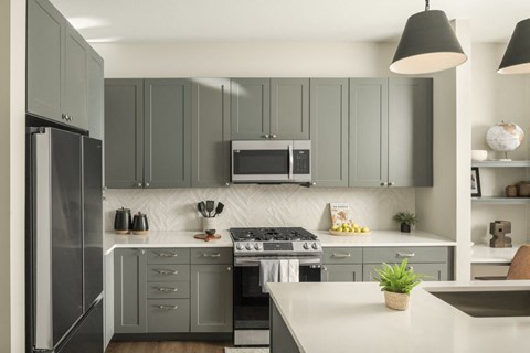 A modern kitchen with a stove top oven and a refrigerator.