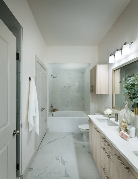 a white bathroom with a tub and a sink and a toilet