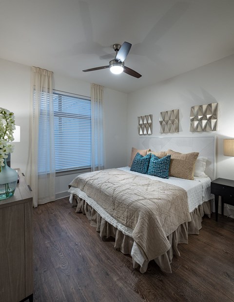 a bedroom with a bed and a ceiling fan