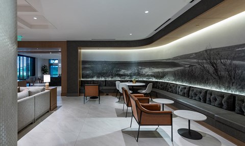 a lobby with tables and chairs and a large mural on the wall