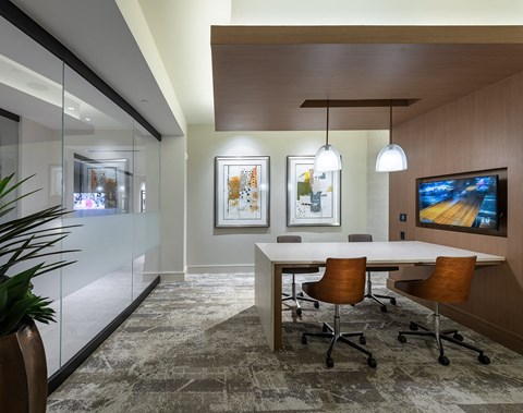 a conference room with a table and chairs and a tv