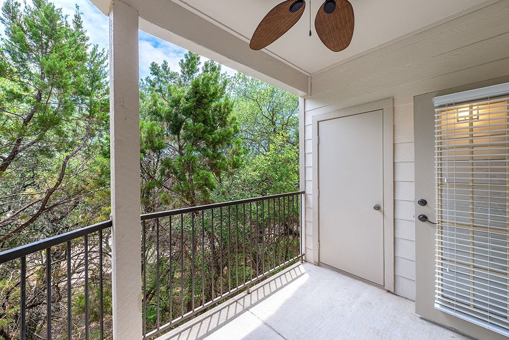 a balcony with a door and a ceiling fan