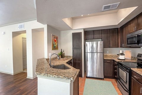 a kitchen with stainless steel appliances and granite counter tops