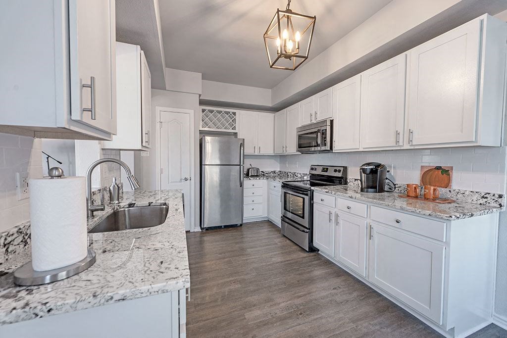 a kitchen with white cabinets and stainless steel appliances