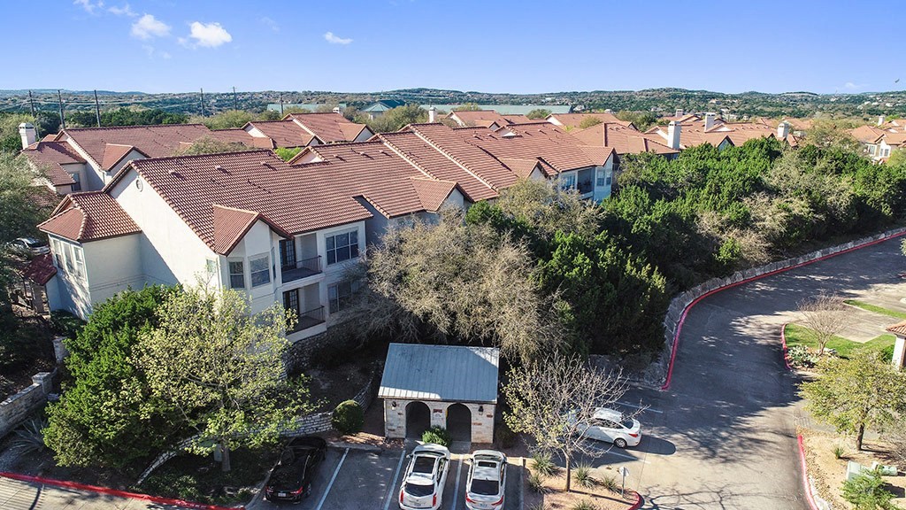 a group of houses with cars parked in a parking lot