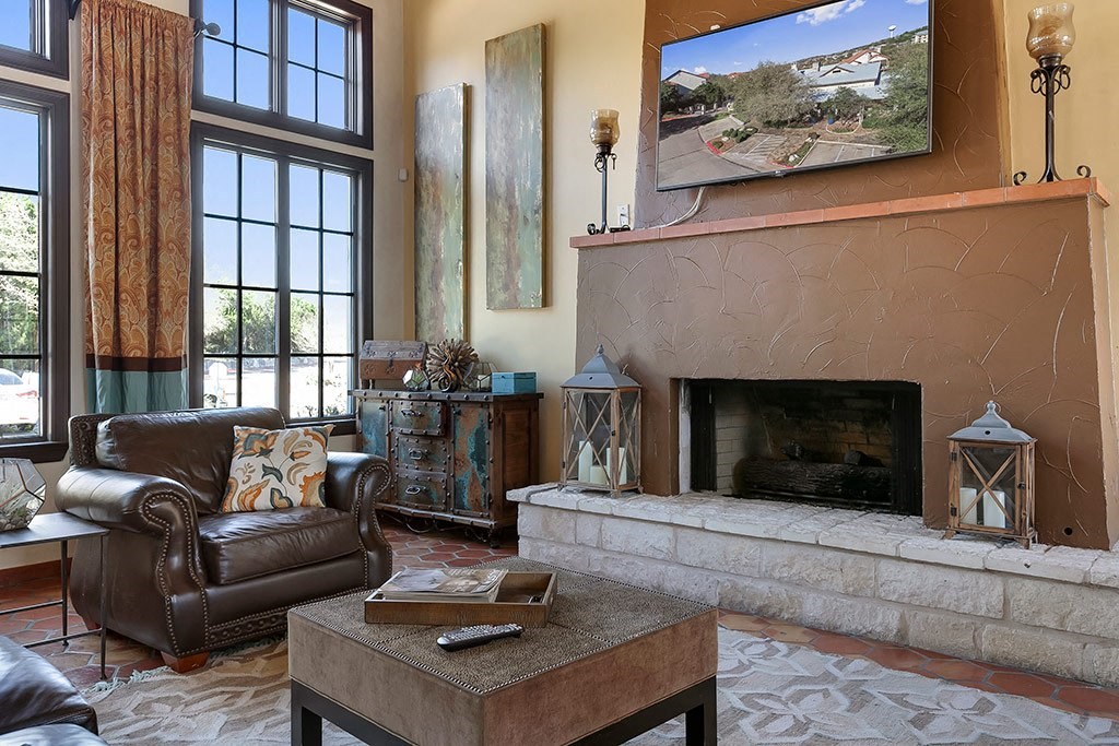a living room with a fireplace and leather furniture