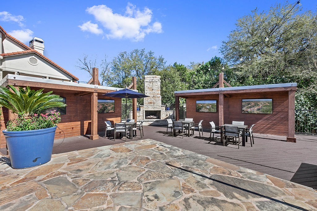 a patio with tables and chairs and a fireplace