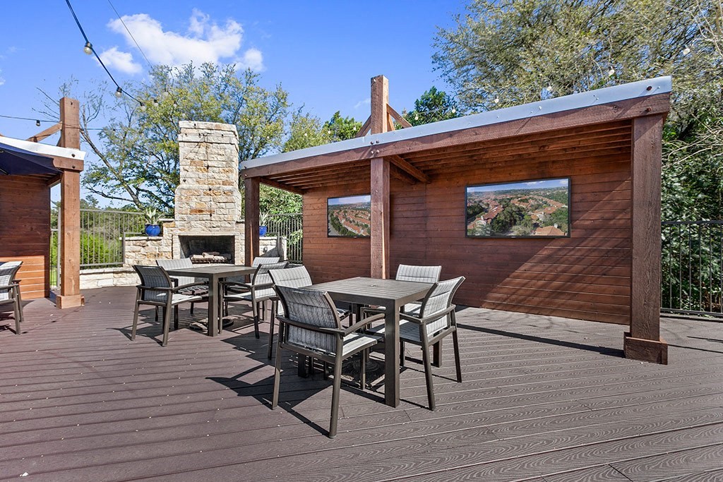 a patio with a table and chairs and a fireplace
