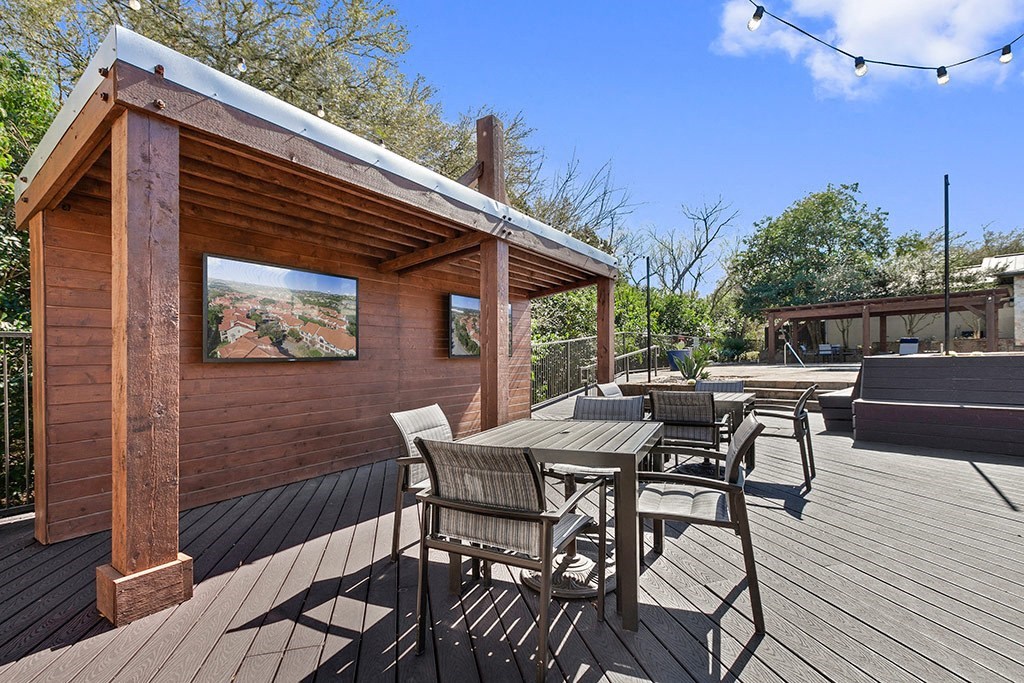 a patio with a table and chairs on a wooden deck