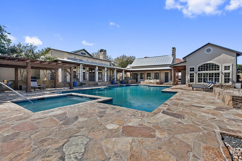 a large pool and spa in the backyard of a house