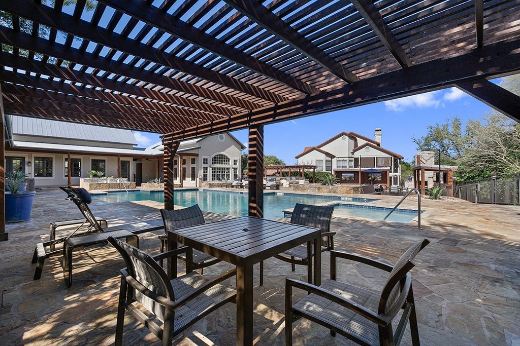 a patio with tables and chairs next to a pool