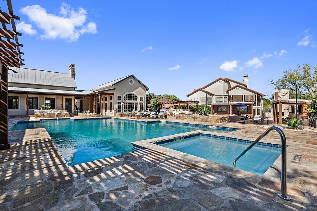 a large swimming pool with a house in the background