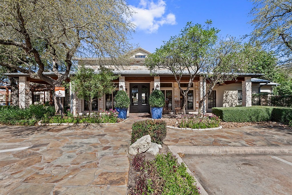the front of a house with a driveway and trees