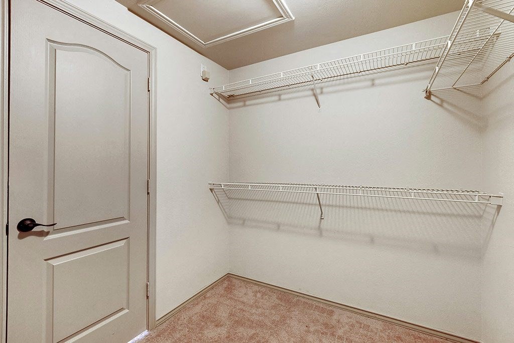 the spacious closet in the bedroom of a home with an open door and a closet