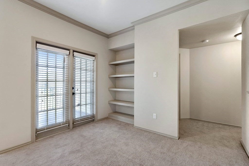 the living room has a large window and a closet with shelves