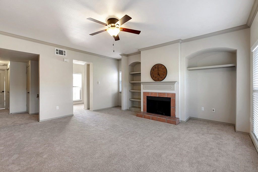 a living room with a fireplace and a ceiling fan